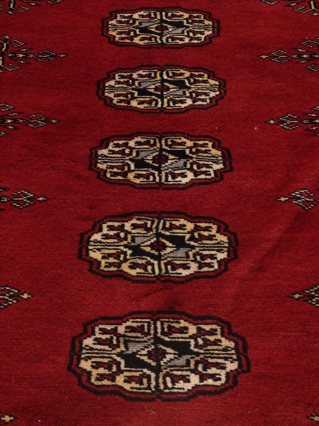 Hand-knotted Pakistan Bokhara rug in deep red with traditional gul motifs