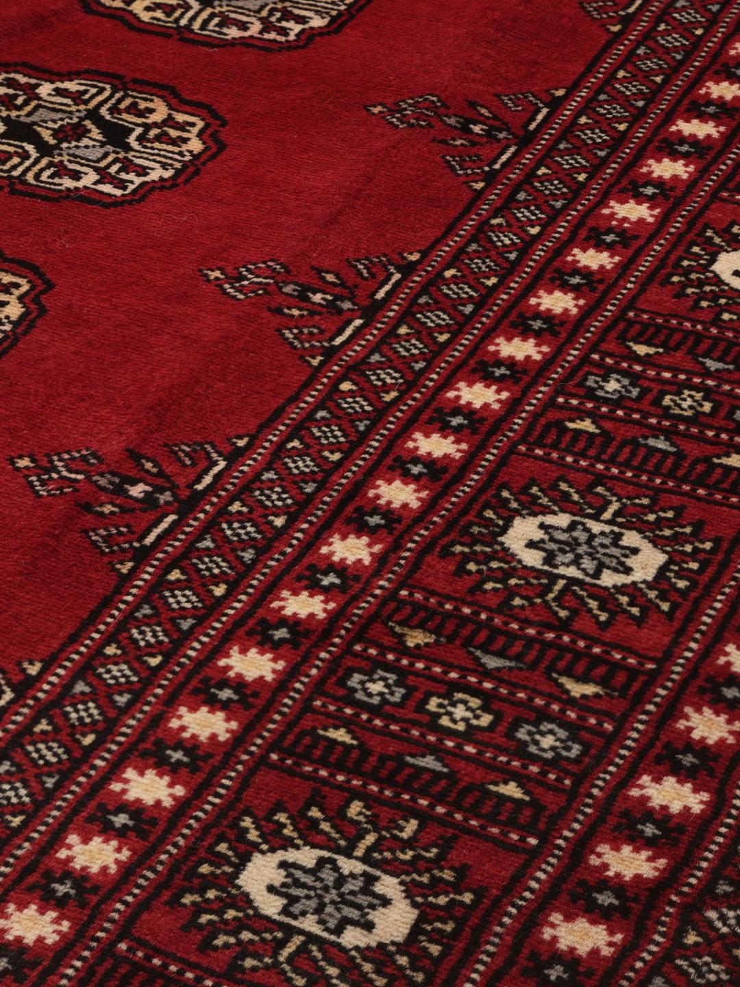 Hand-knotted Pakistan Bokhara rug in deep red with traditional gul motifs