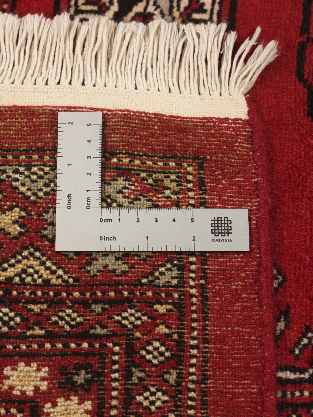 Hand-knotted Pakistan Bokhara rug in deep red with traditional gul motifs