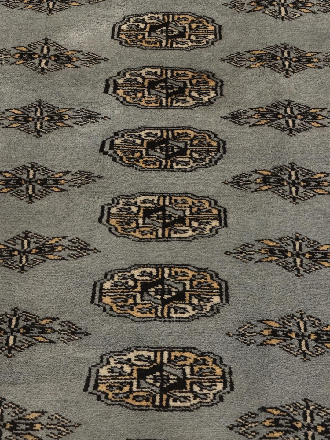 Handgeknoopt Pakistan Bokhara vloerkleed in een lichtgrijze tint met traditionele geometrische motieven.