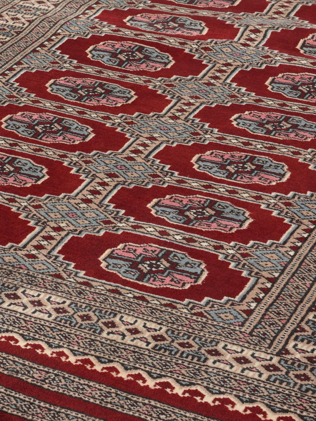 A hand-knotted Pakistan Bokhara rug with a dark-red field and classic geometric motifs.