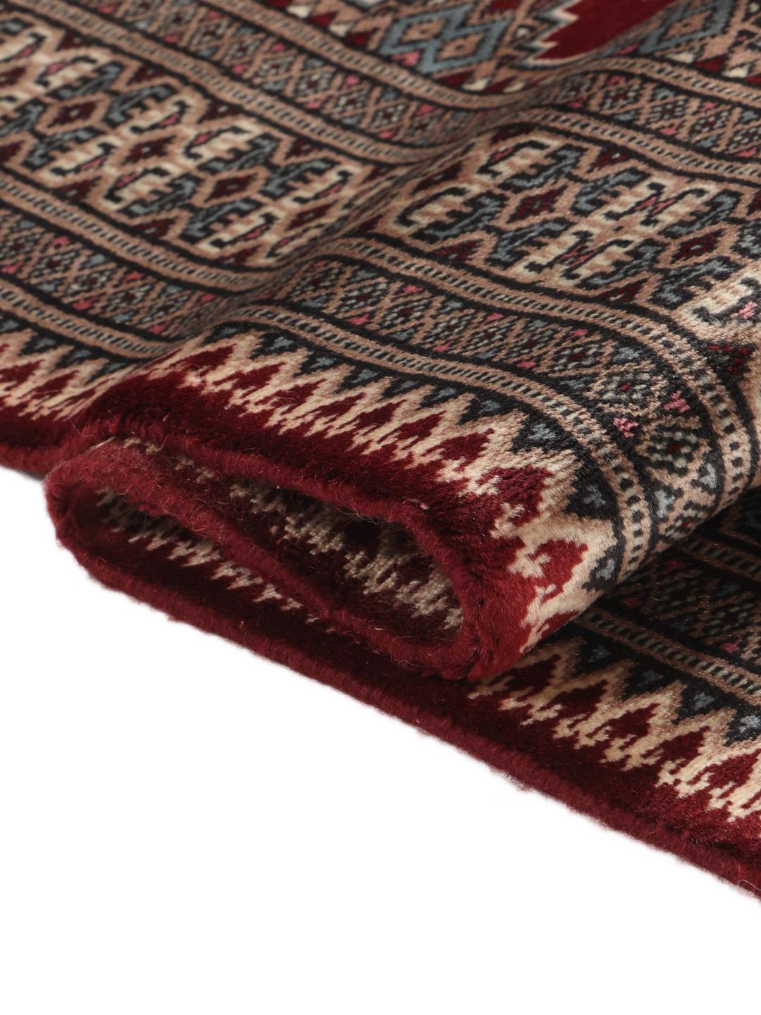 A hand-knotted Pakistan Bokhara rug with a dark-red field and classic geometric motifs.