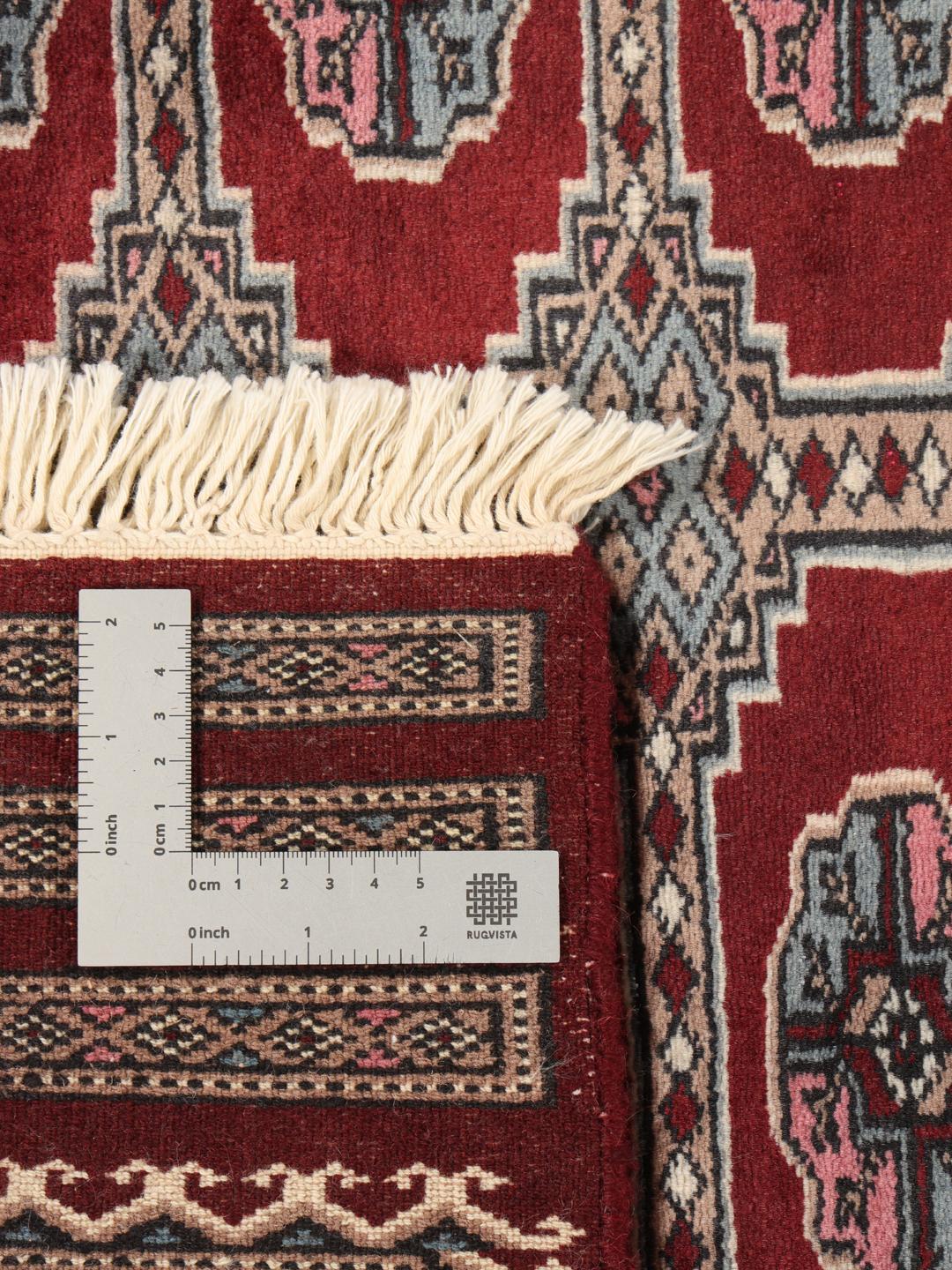 A hand-knotted Pakistan Bokhara rug with a dark-red field and classic geometric motifs.