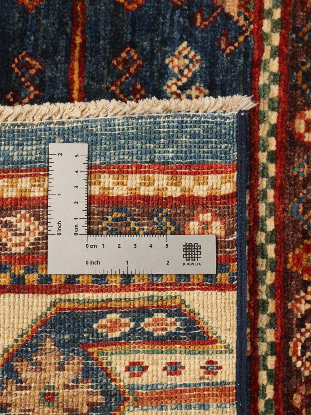 Een rechthoekig handgemaakt Afghaans tapijt met een veelkleurig gestreept en geometrisch patroon.