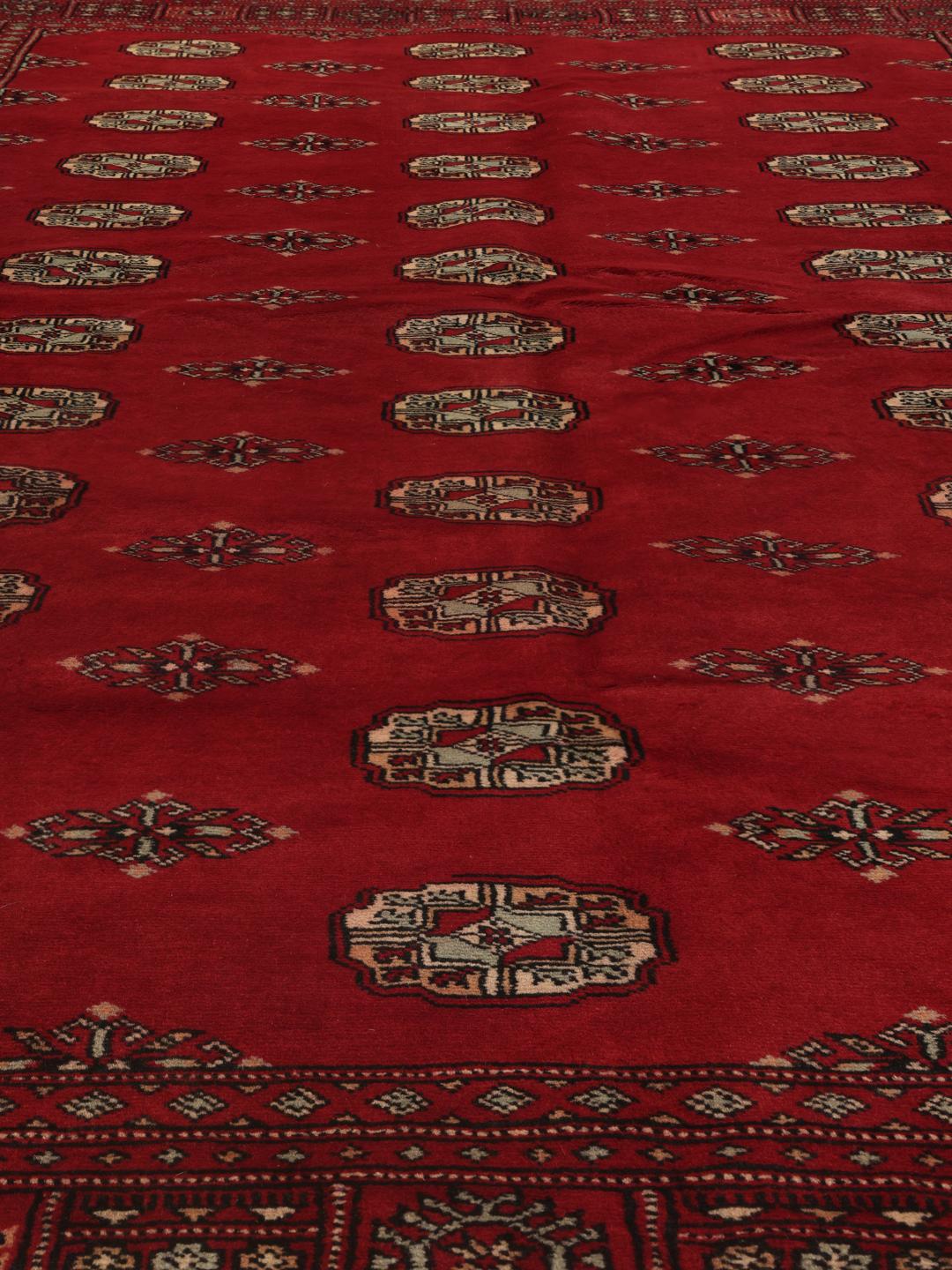 A hand-knotted Pakistan Bokhara 2ply rug in deep red with traditional medallion patterns.