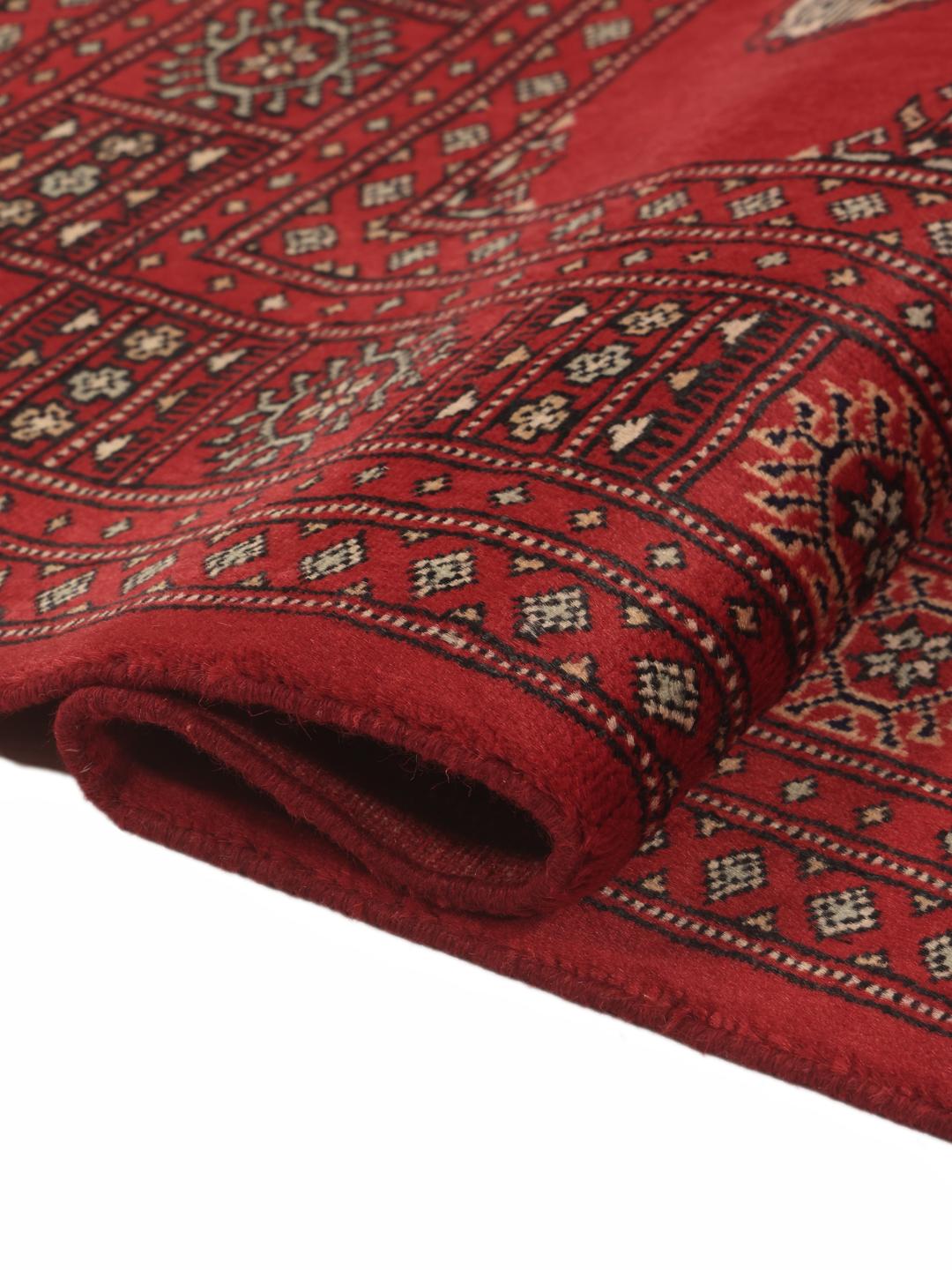 A hand-knotted Pakistan Bokhara 2ply rug in deep red with traditional medallion patterns.