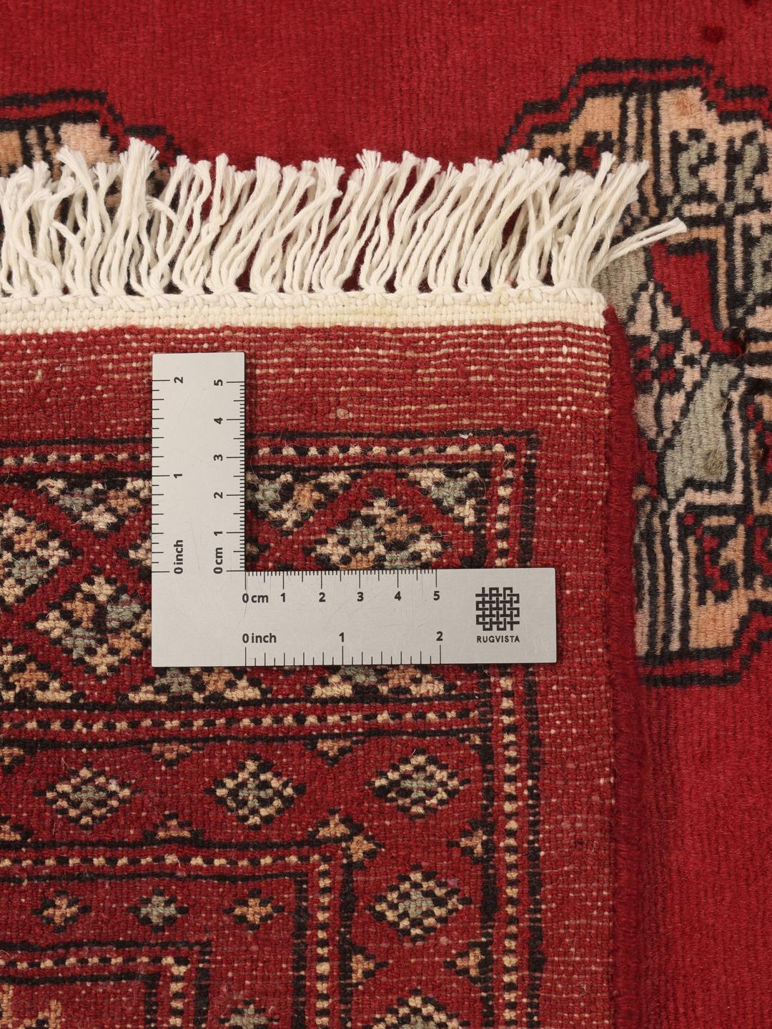A hand-knotted Pakistan Bokhara 2ply rug in deep red with traditional medallion patterns.