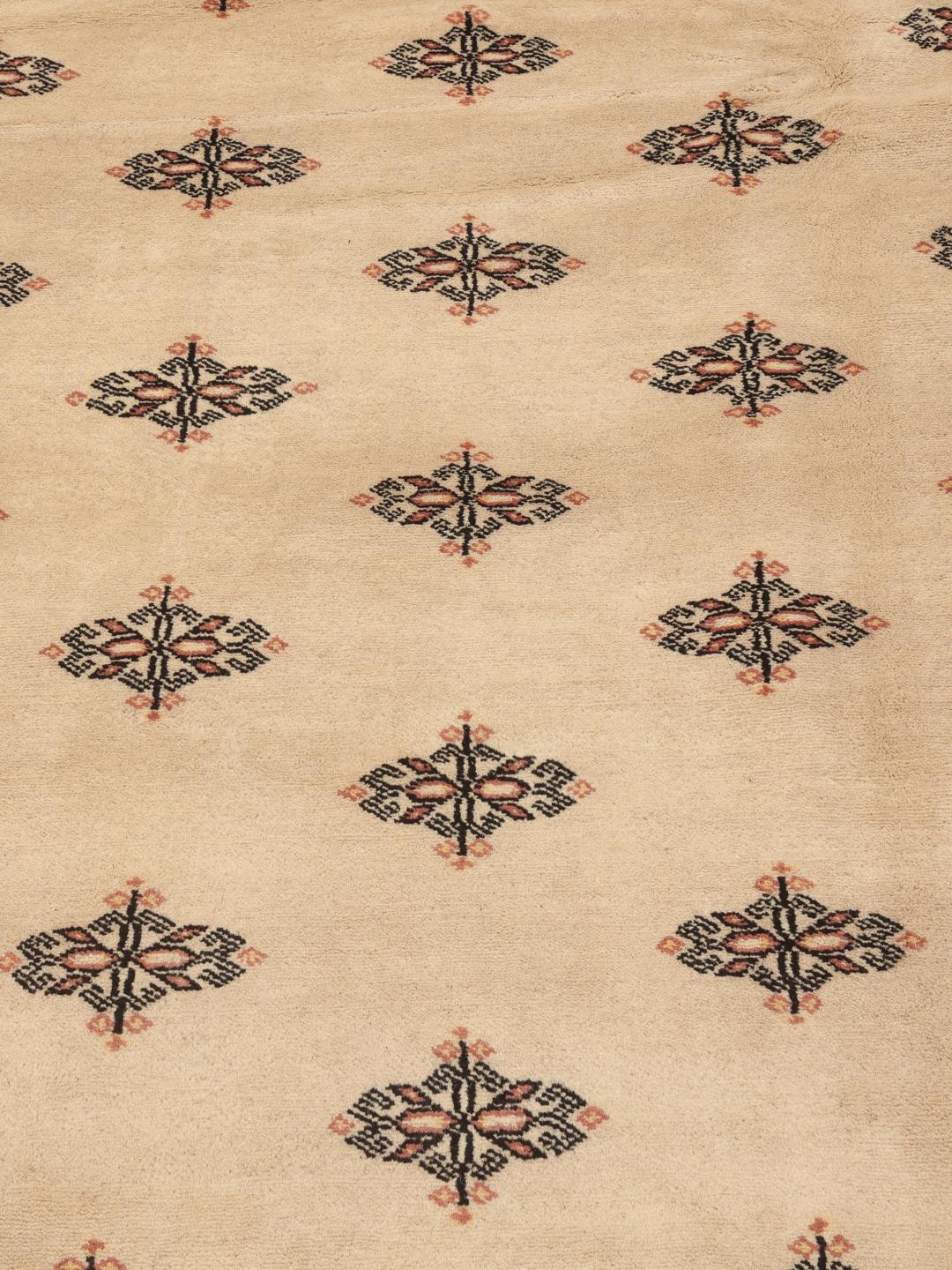 Hand-knotted Pakistan Bokhara rug with a beige field and traditional motifs