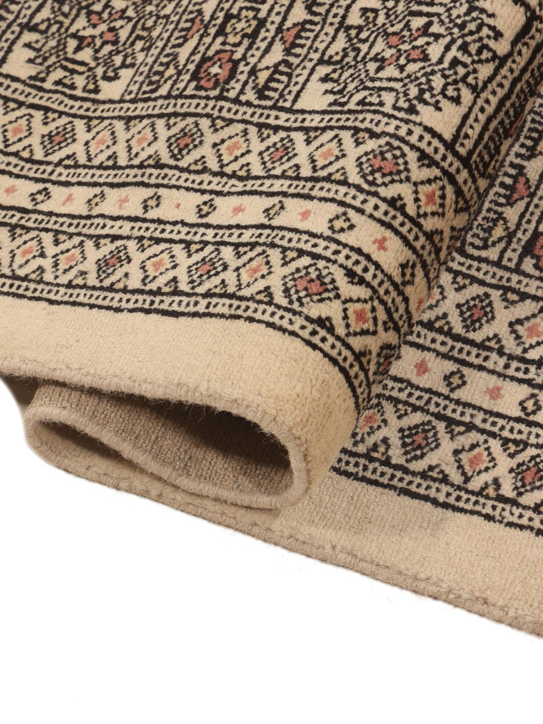 Hand-knotted Pakistan Bokhara rug with a beige field and traditional motifs