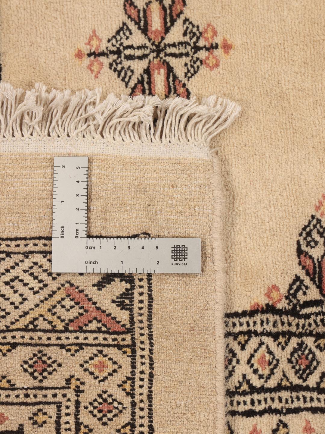 Hand-knotted Pakistan Bokhara rug with a beige field and traditional motifs