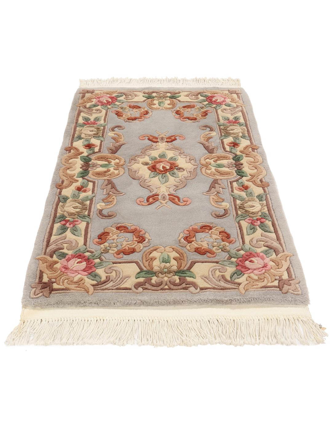 Un tapis rectangulaire noué à la main provenant de Chine, présentant un motif de médaillon floral bleu clair.