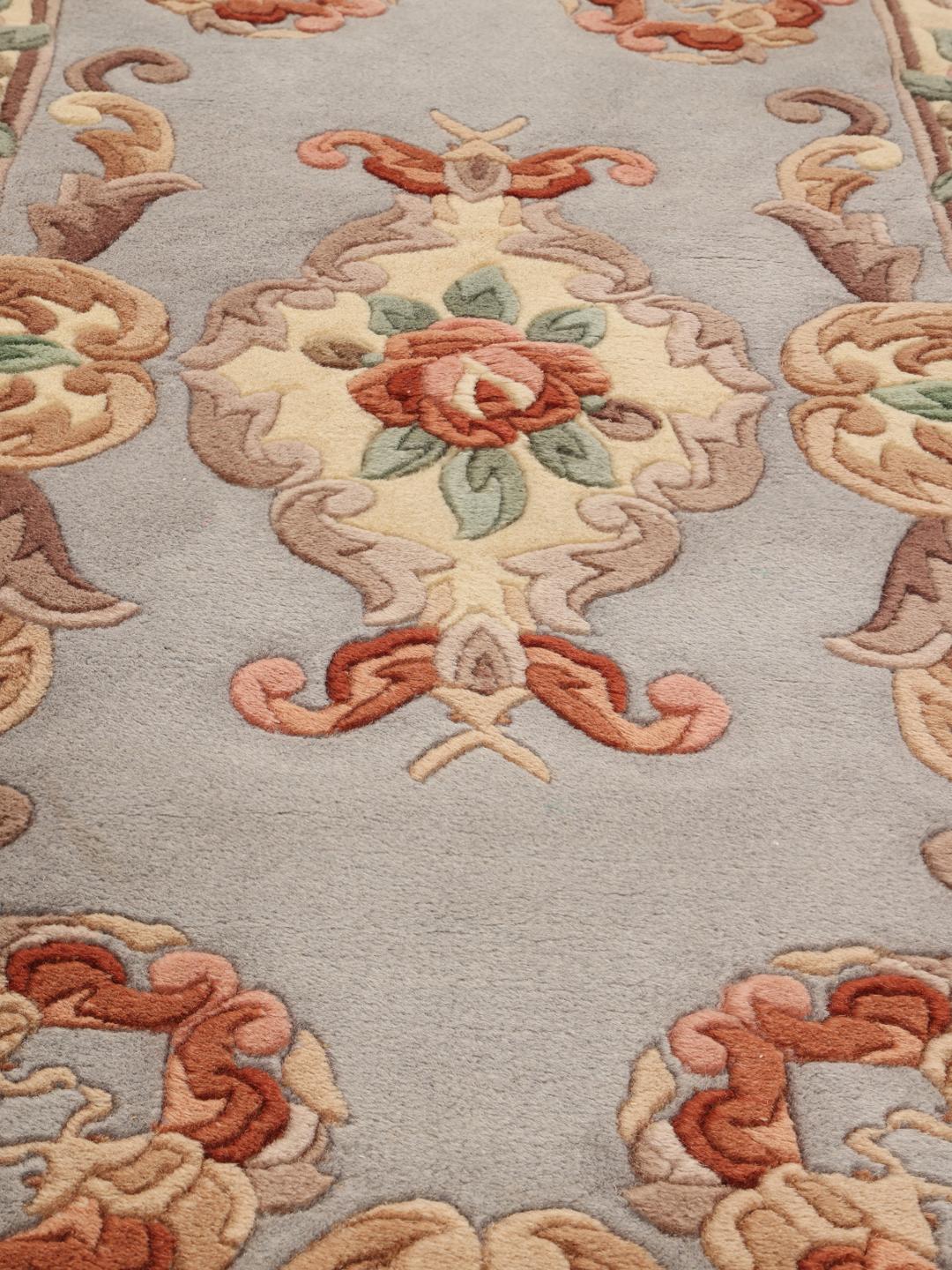 Un tapis rectangulaire noué à la main provenant de Chine, présentant un motif de médaillon floral bleu clair.