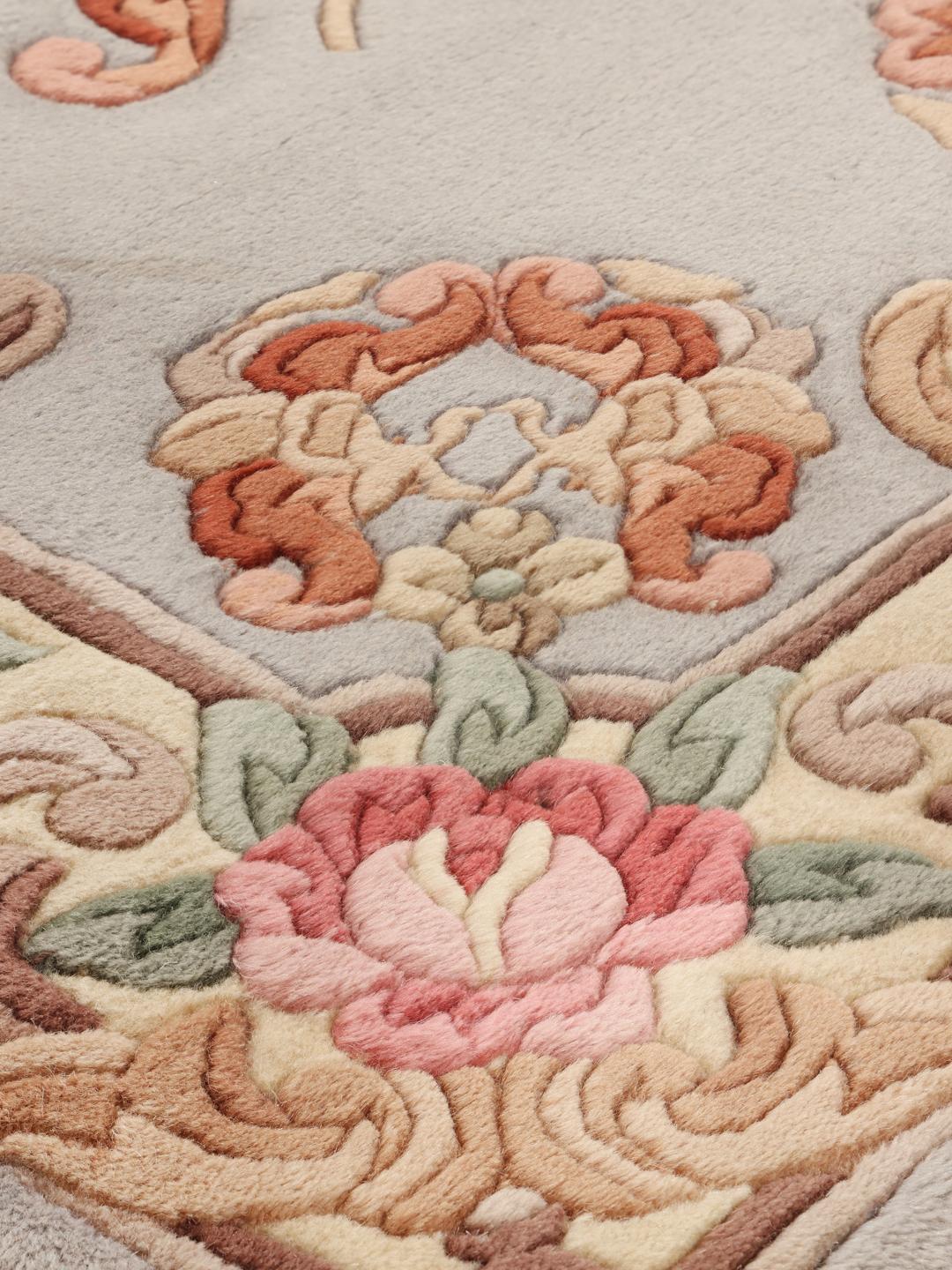 Un tapis rectangulaire noué à la main provenant de Chine, présentant un motif de médaillon floral bleu clair.