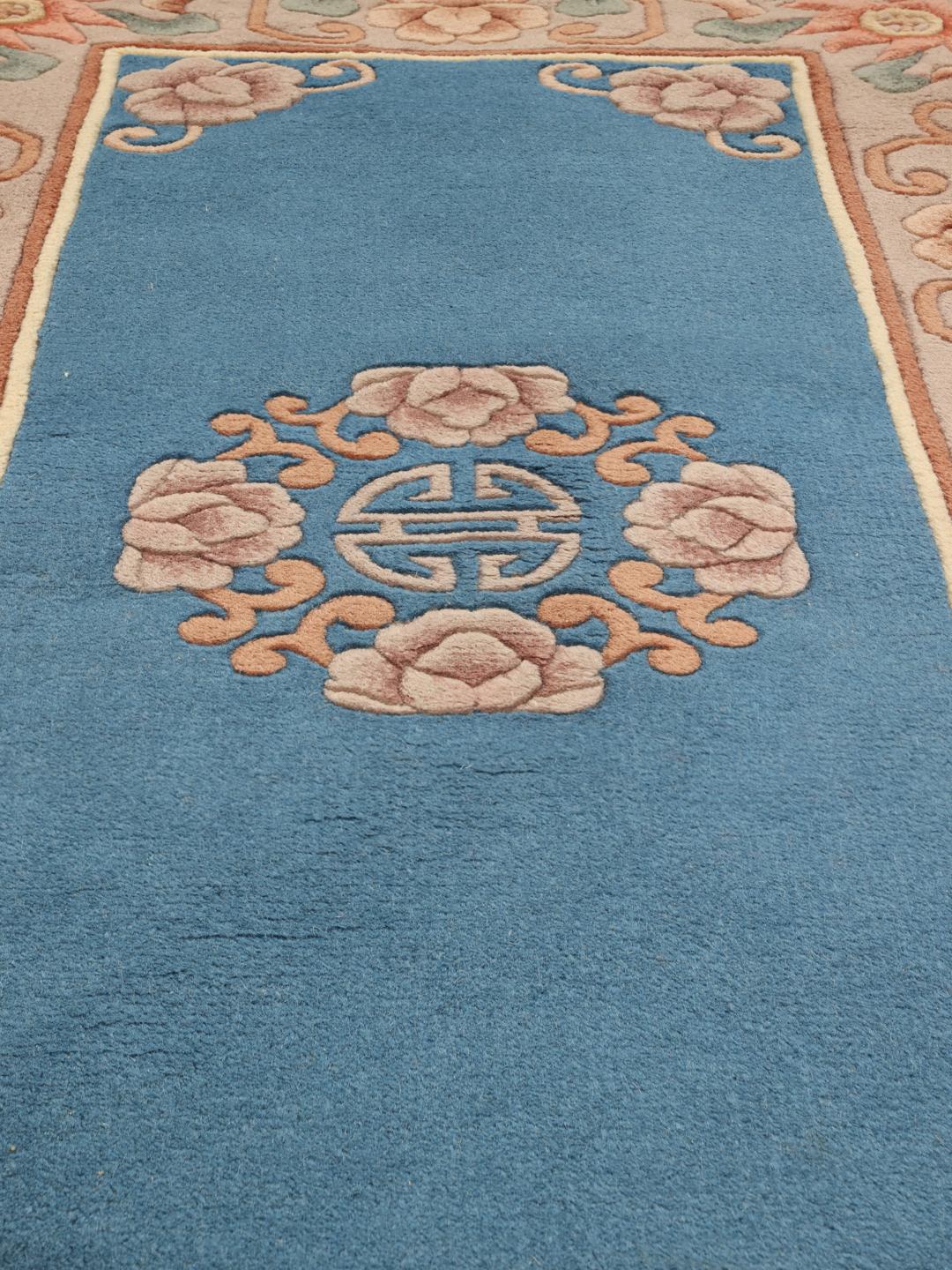 Håndknyttet kinesisk tæppe med blomstermotiver i blå og bløde pasteltoner
