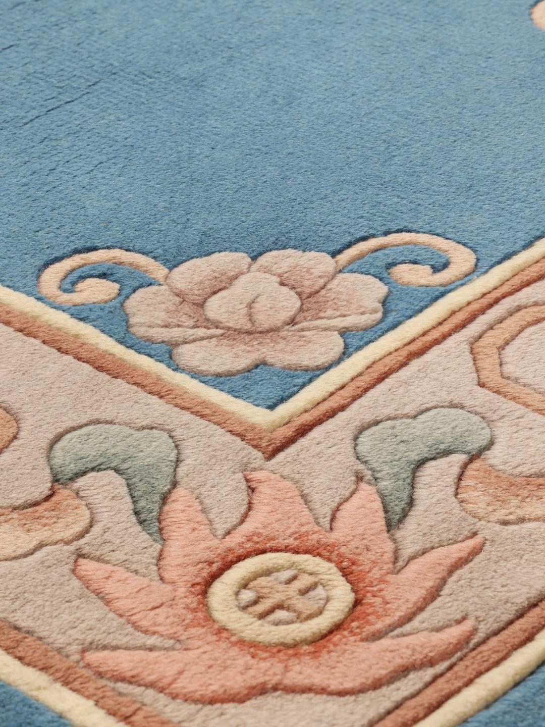 Håndknyttet kinesisk tæppe med blomstermotiver i blå og bløde pasteltoner