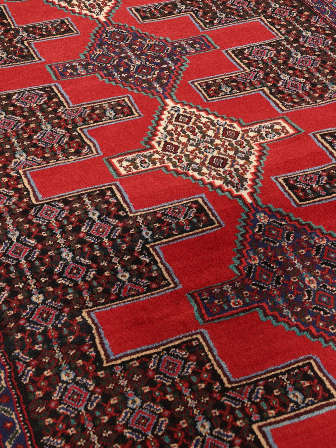 A hand-knotted Senneh runner from the Middle East in dark-red and black tones.