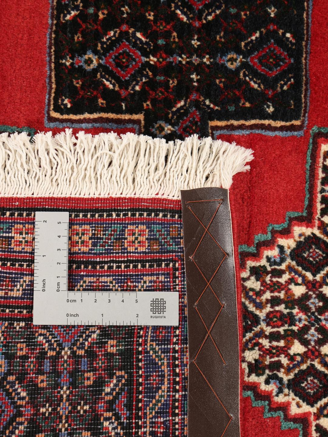 A hand-knotted Senneh runner from the Middle East in dark-red and black tones.