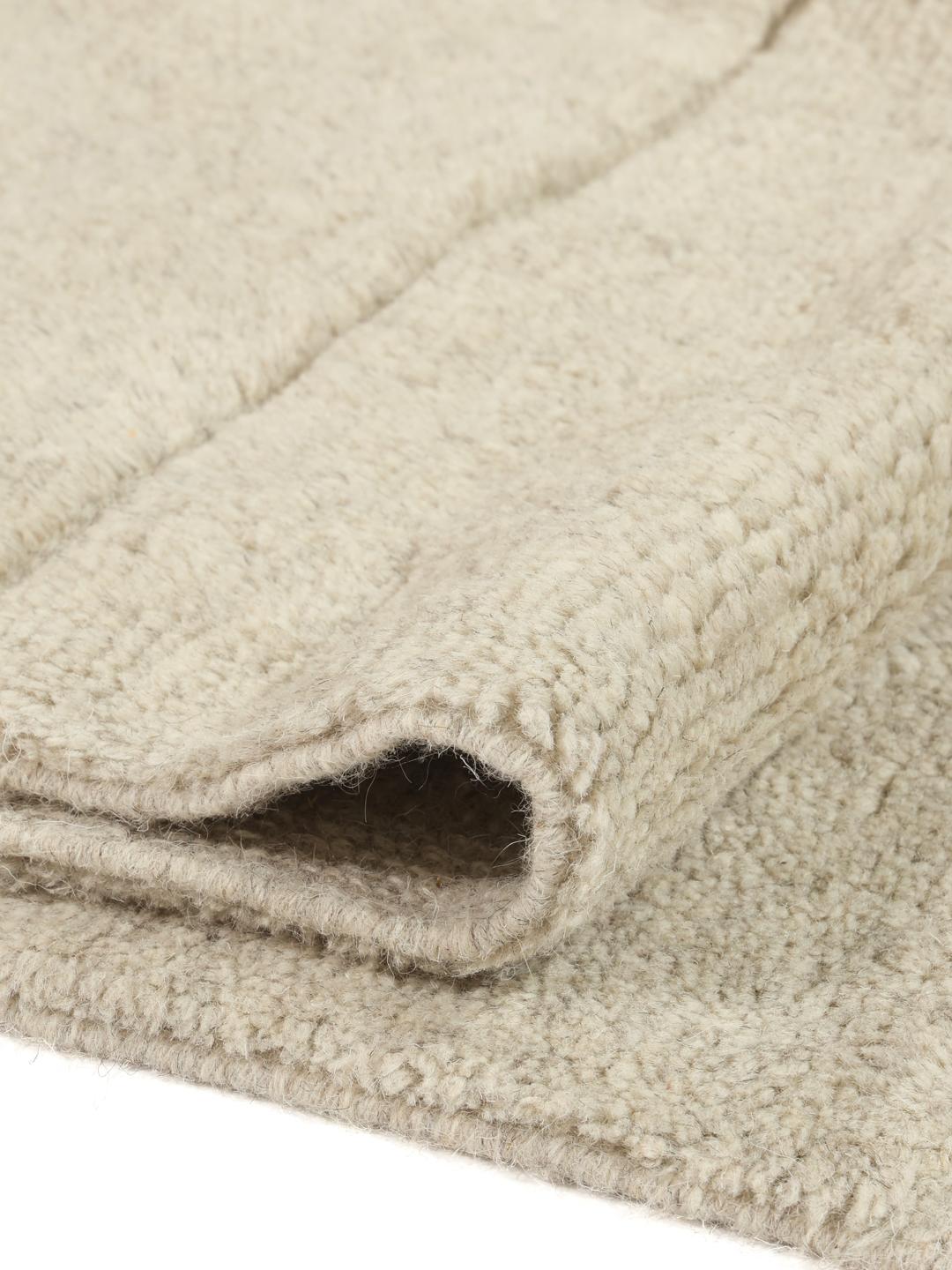Beige tæppe med detaljer i høj og lav luv