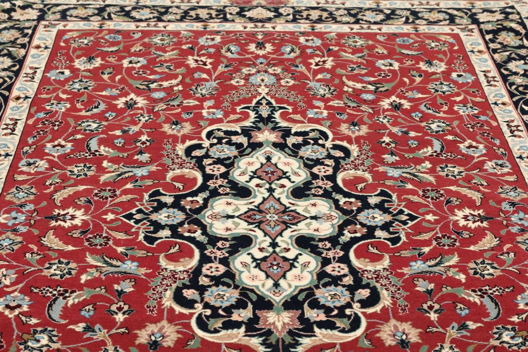 Een met de hand geknoopt Ilam Sherkat Farsh tapijt uit het Midden-Oosten met een rood veld en donkere bloemenranden.