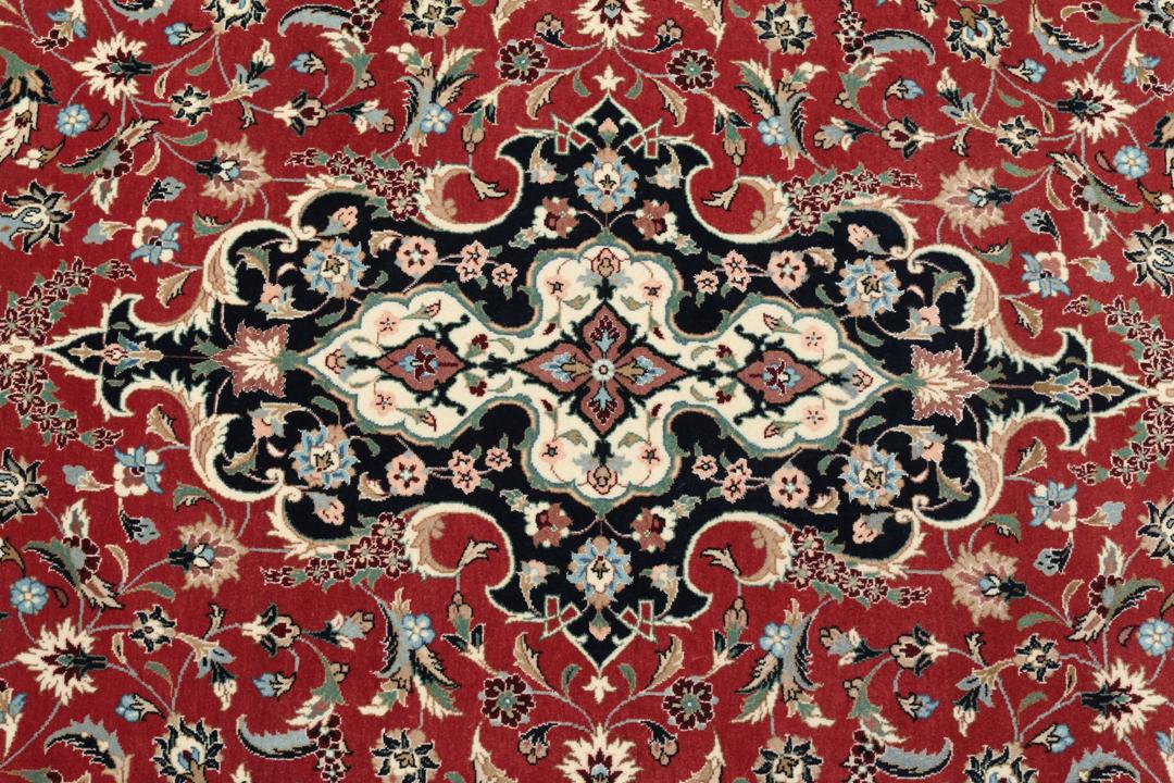 Een met de hand geknoopt Ilam Sherkat Farsh tapijt uit het Midden-Oosten met een rood veld en donkere bloemenranden.