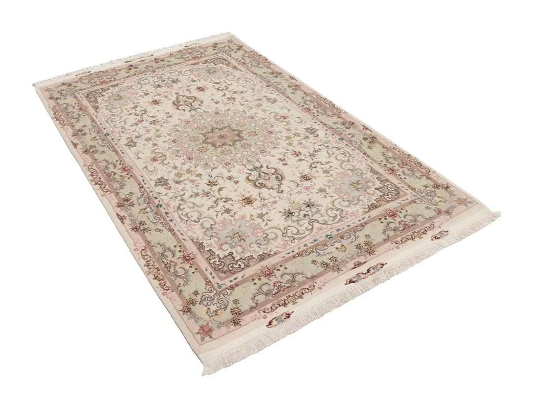 Een handgeknoopt Tabriz-tapijt uit het Midden-Oosten met een bloemenmedaillonpatroon in groen en roze.