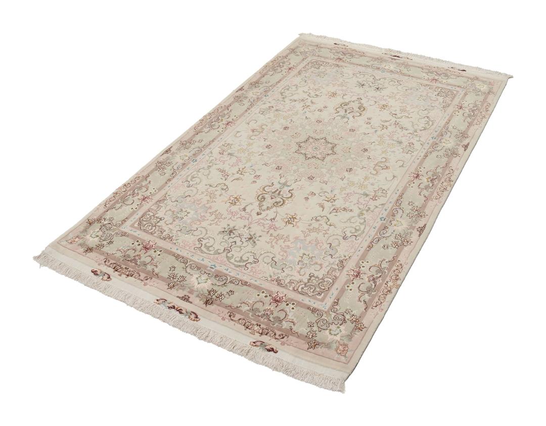 Een handgeknoopt Tabriz-tapijt uit het Midden-Oosten met een bloemenmedaillonpatroon in groen en roze.