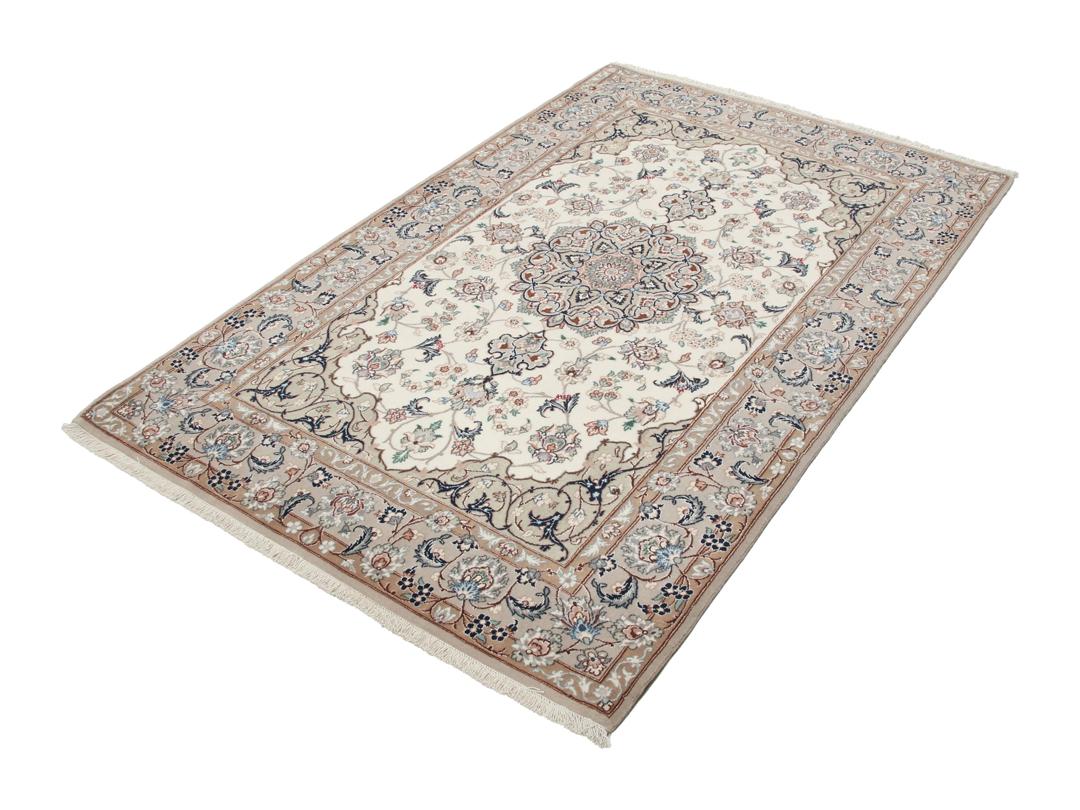 Et håndknyttet Isfahan-tæppe med blomstermedaljonmønstre i beige og dæmpede toner.