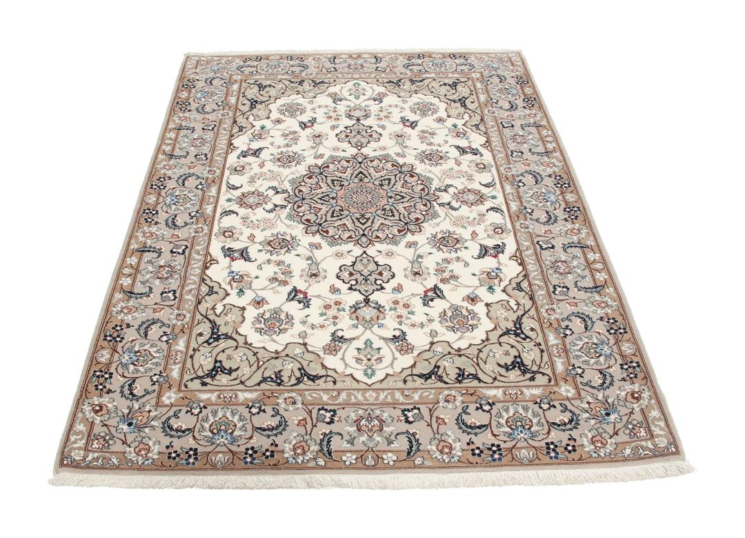 Et håndknyttet Isfahan-tæppe med blomstermedaljonmønstre i beige og dæmpede toner.