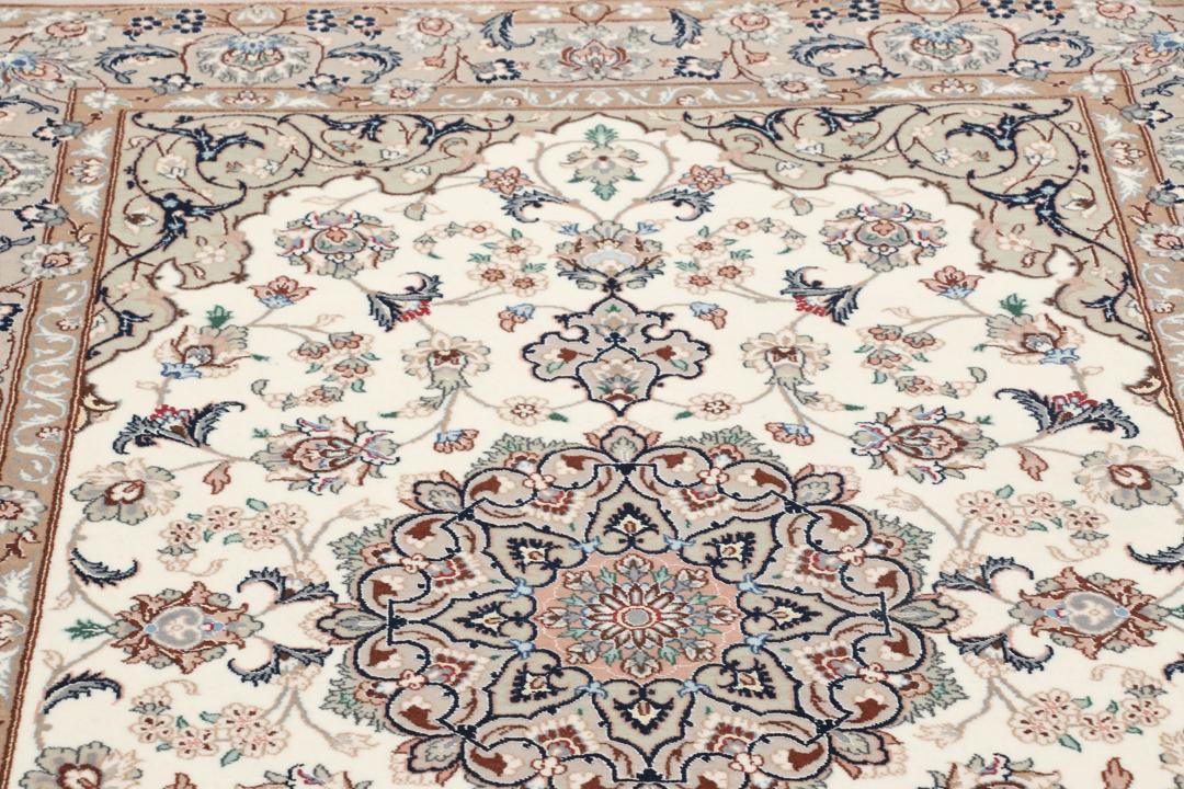 Et håndknyttet Isfahan-tæppe med blomstermedaljonmønstre i beige og dæmpede toner.