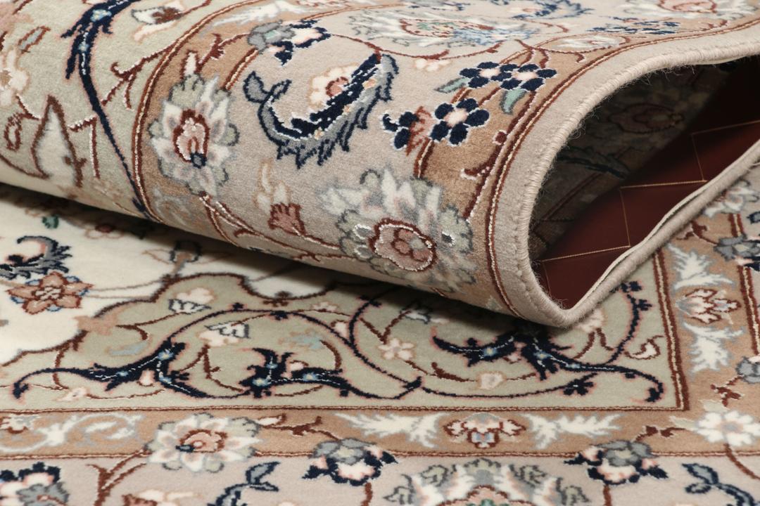 Et håndknyttet Isfahan-tæppe med blomstermedaljonmønstre i beige og dæmpede toner.