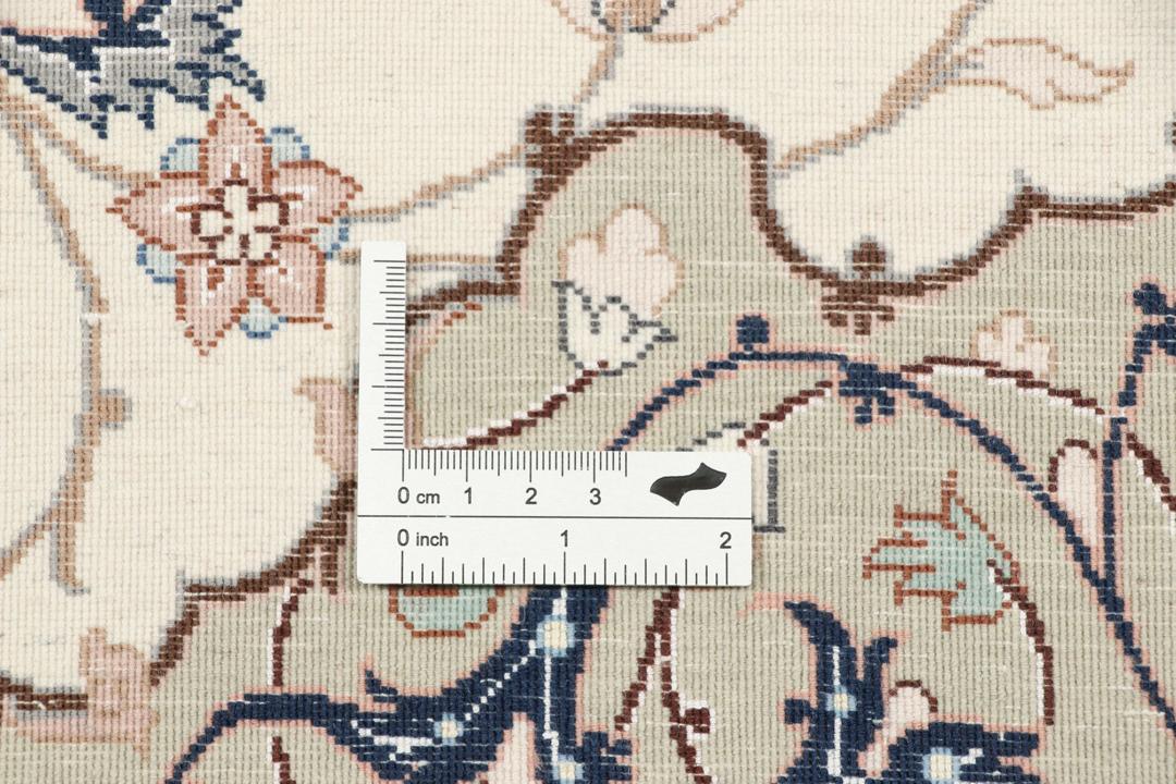 Et håndknyttet Isfahan-tæppe med blomstermedaljonmønstre i beige og dæmpede toner.