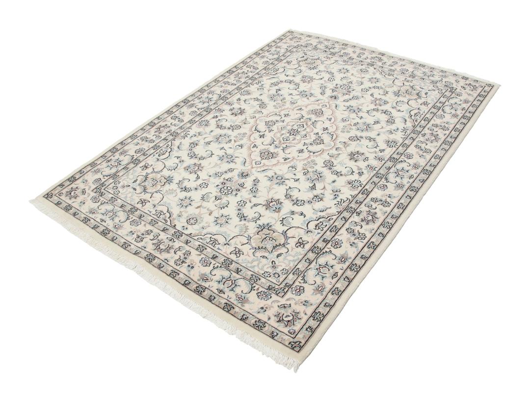 Et håndknyttet Nain-tæppe fra Mellemøsten med en beige bund og blomstermotiver.