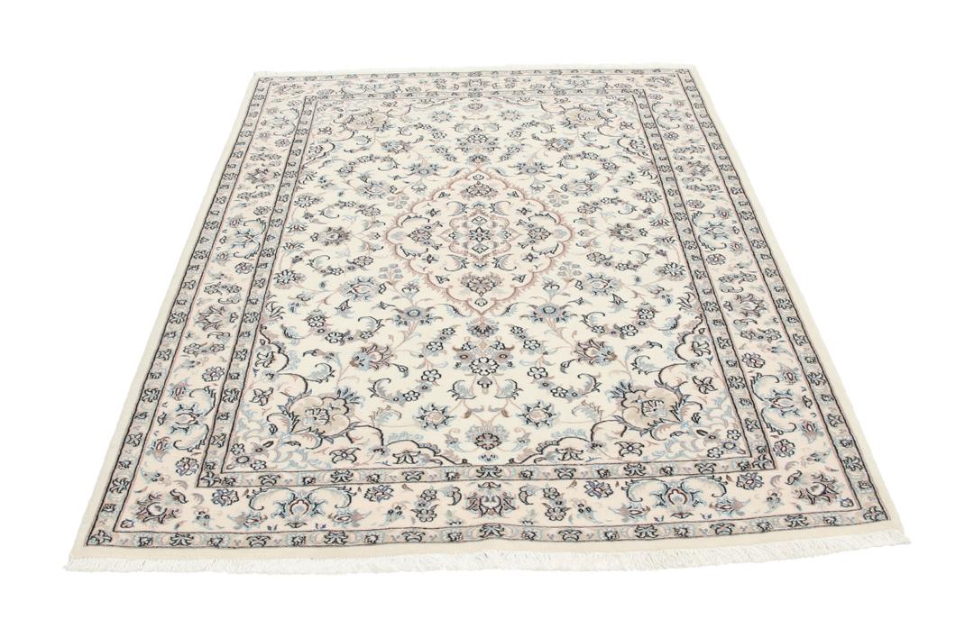 Et håndknyttet Nain-tæppe fra Mellemøsten med en beige bund og blomstermotiver.