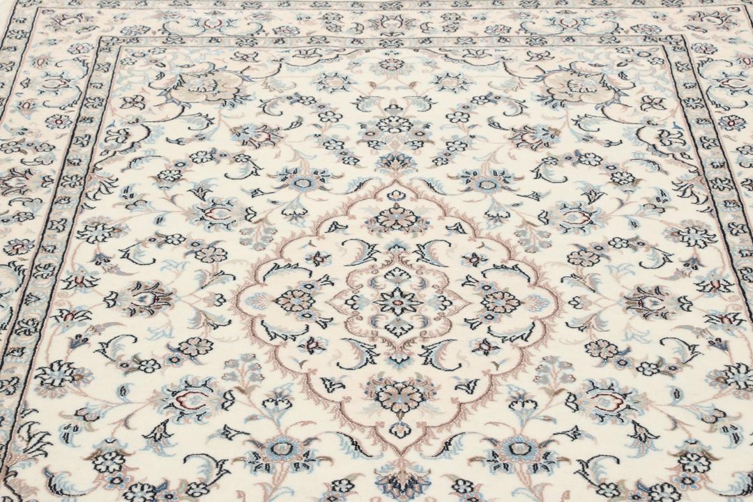 Et håndknyttet Nain-tæppe fra Mellemøsten med en beige bund og blomstermotiver.
