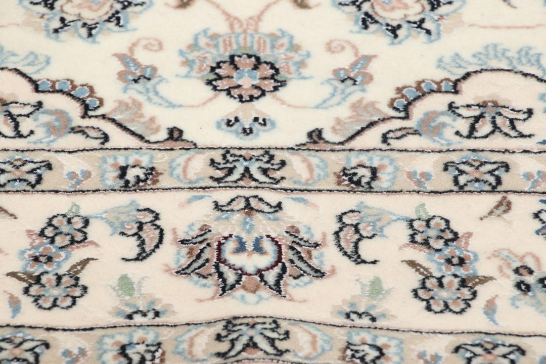 Et håndknyttet Nain-tæppe fra Mellemøsten med en beige bund og blomstermotiver.
