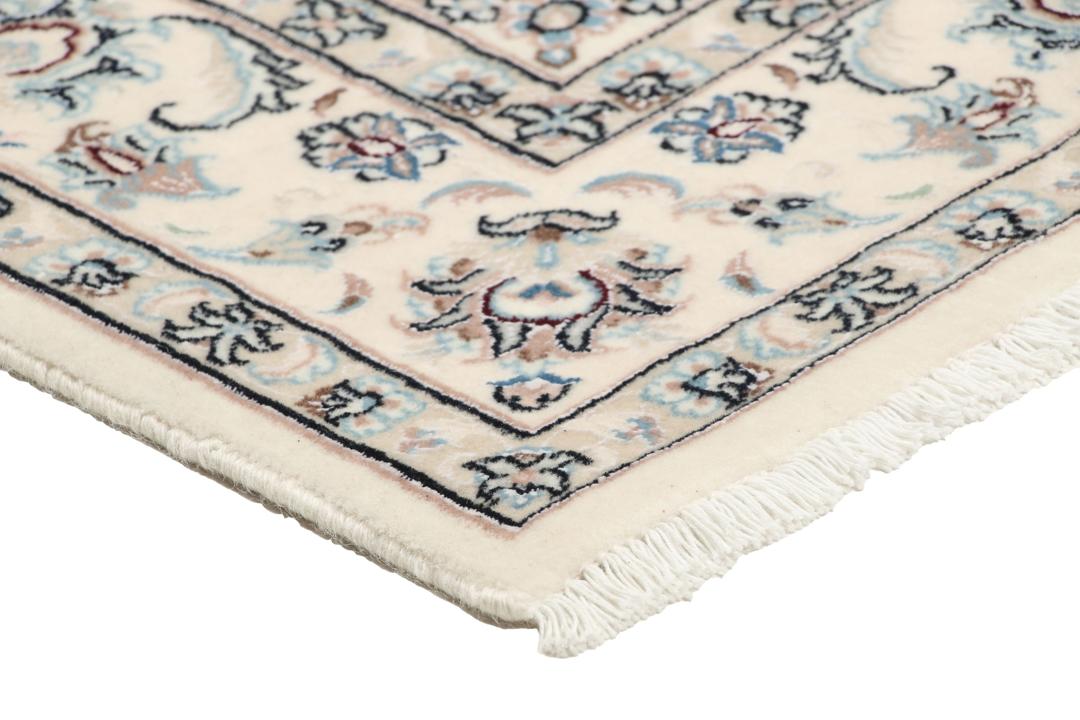 Et håndknyttet Nain-tæppe fra Mellemøsten med en beige bund og blomstermotiver.