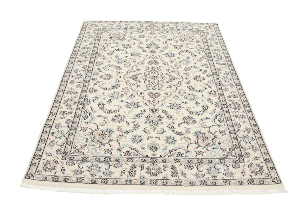 Et håndknyttet Nain 6La tæppe med blomstermønstre i beige og blå nuancer.