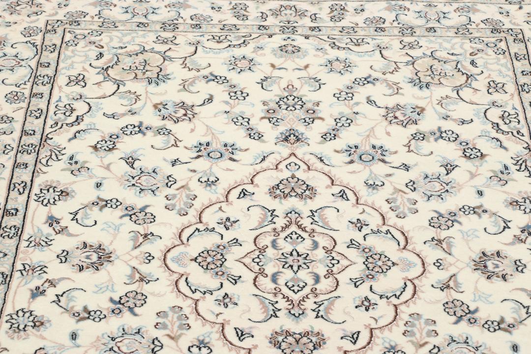 Et håndknyttet Nain 6La tæppe med blomstermønstre i beige og blå nuancer.