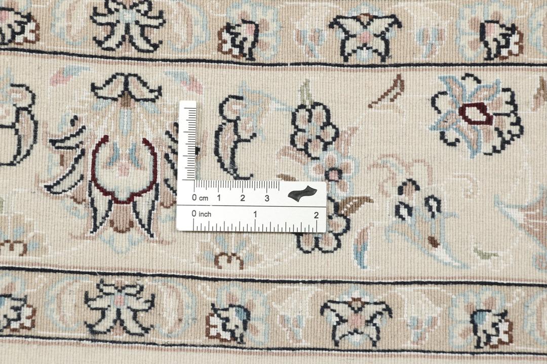 Et håndknyttet Nain 6La tæppe med blomstermønstre i beige og blå nuancer.