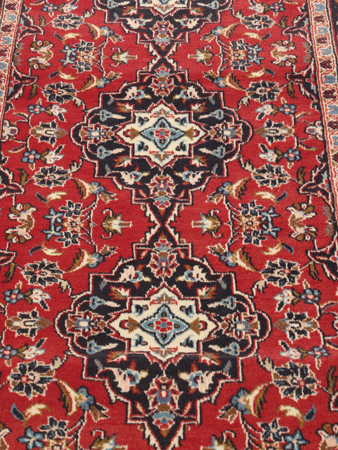 Hand-knotted Keshan runner rug with a classic floral medallion design in red and blue.