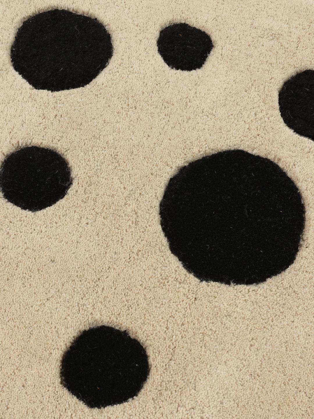 Een speels tapijt in de vorm van een kat in beige en donkergrijs met een zachte wollen pool