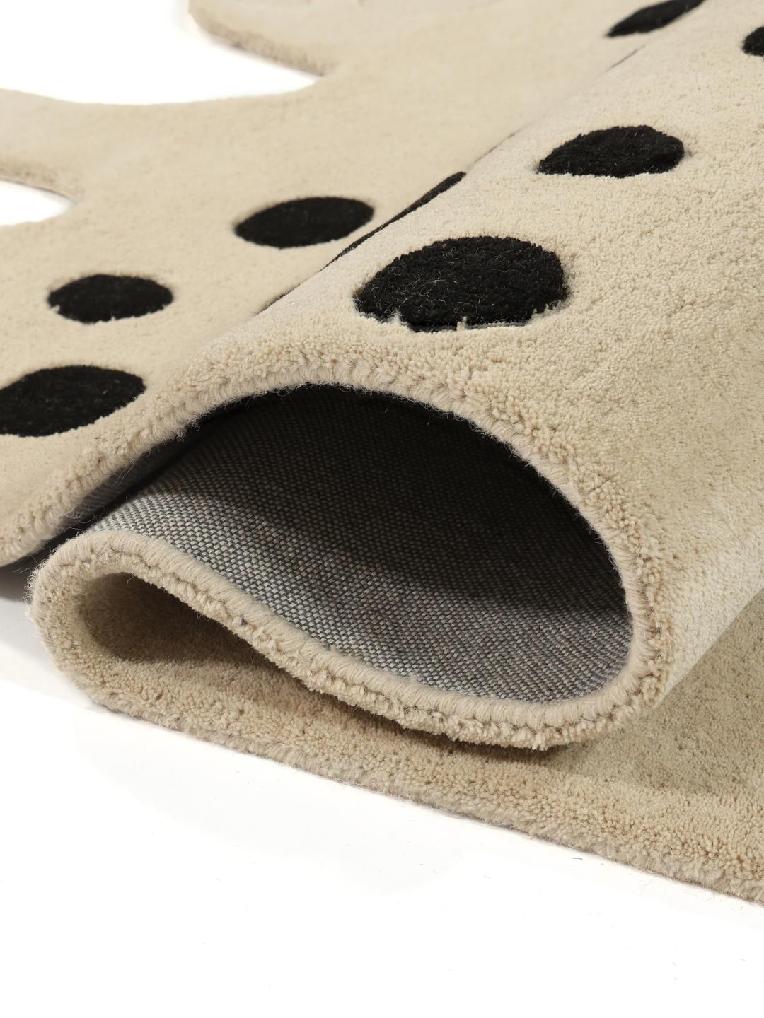 Een speels tapijt in de vorm van een kat in beige en donkergrijs met een zachte wollen pool