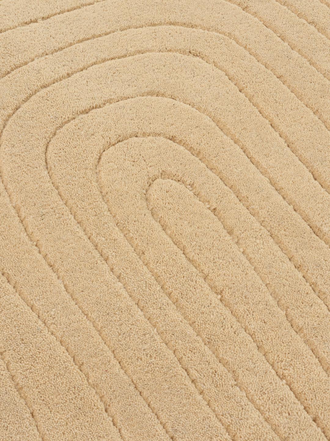 Beige tæppe med uregelmæssig form og høj og lav luv