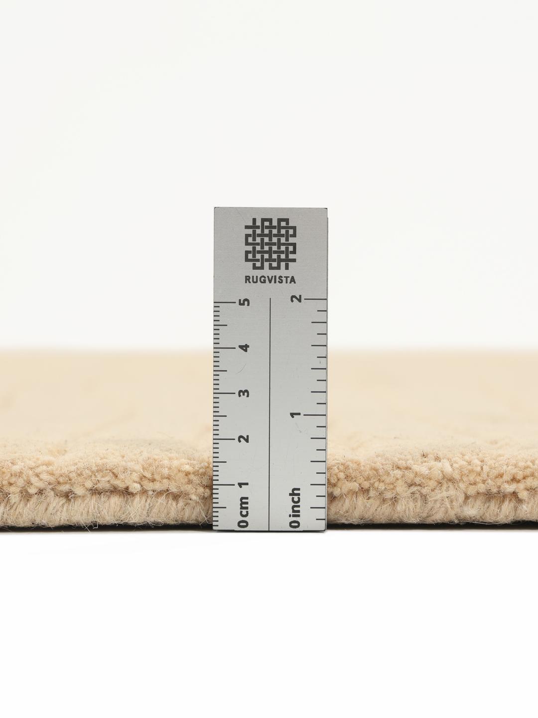Beige tæppe med uregelmæssig form og høj og lav luv