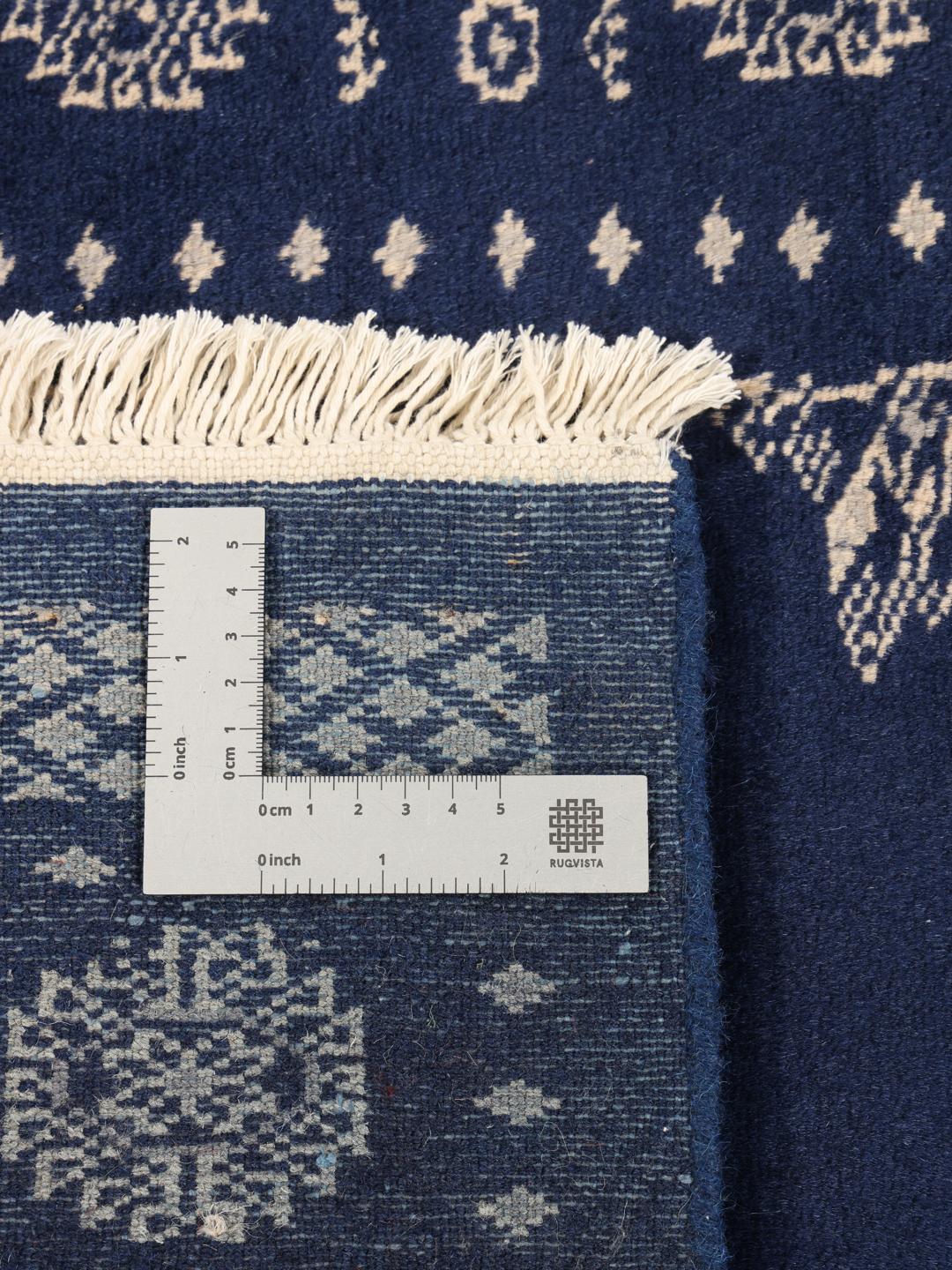 Hand-knotted Pakistan Bokhara rug with a deep blue field and intricate light-toned motifs