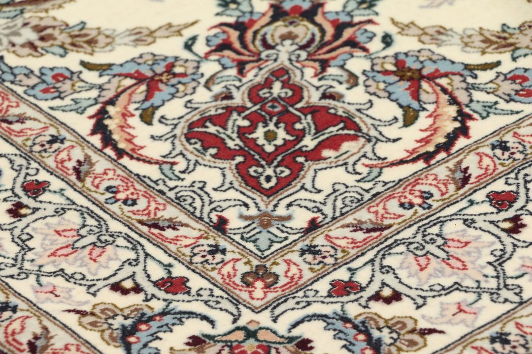 Håndknyttet Isfahan-tæppe fra Mellemøsten i beige og røde nuancer.