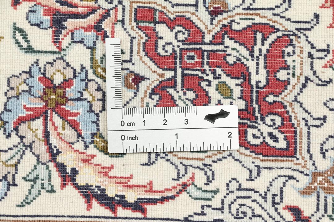 Håndknyttet Isfahan-tæppe fra Mellemøsten i beige og røde nuancer.