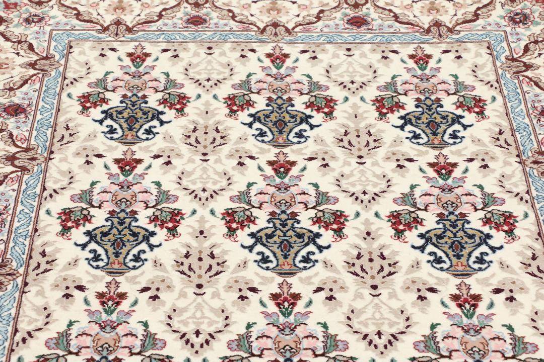Håndknyttet Isfahan-tæppe fra Mellemøsten med blomstermotiver i beige, blå og rød.