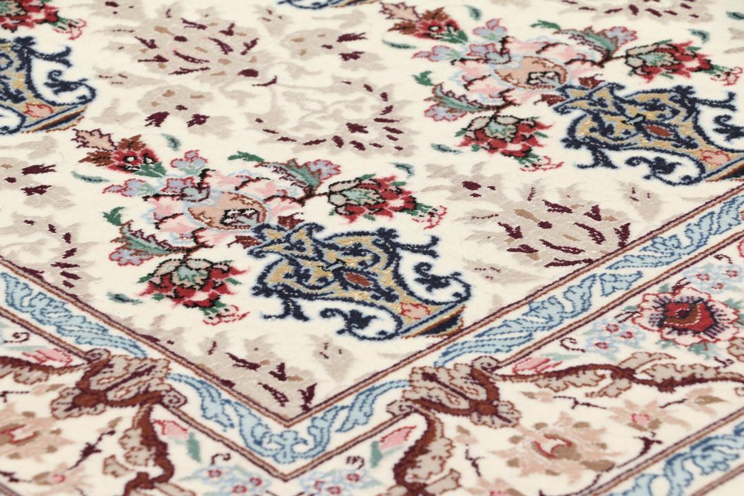 Håndknyttet Isfahan-tæppe fra Mellemøsten med blomstermotiver i beige, blå og rød.