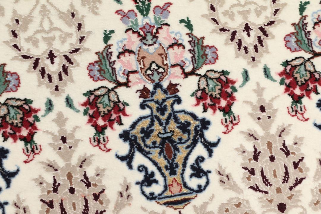 Håndknyttet Isfahan-tæppe fra Mellemøsten med blomstermotiver i beige, blå og rød.
